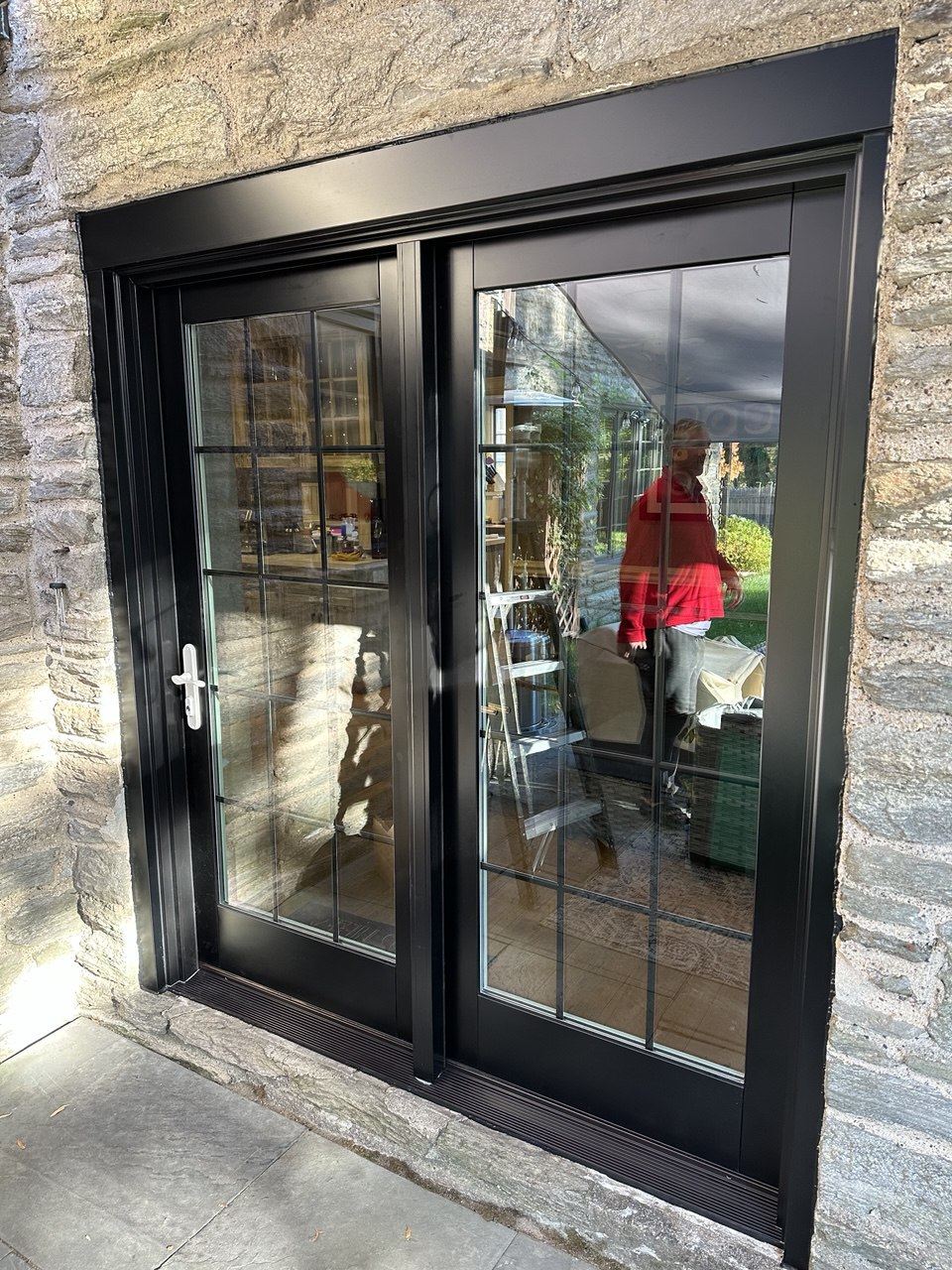 Black French doors on stone facade