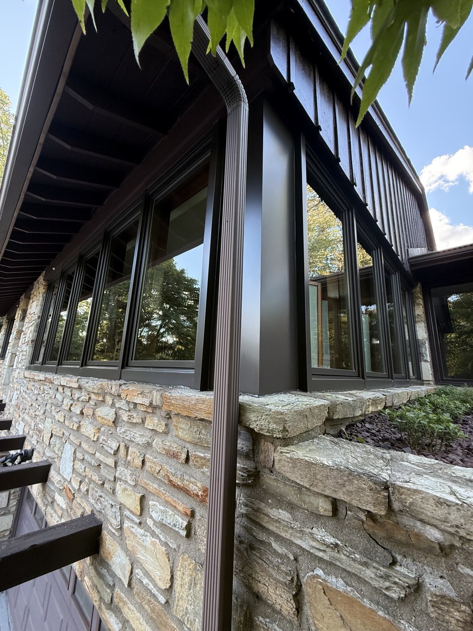 Modern black window wall on stone facade